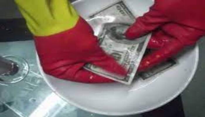 Person cleaning defaced banknotes using SSD solution in a secure lab setup.